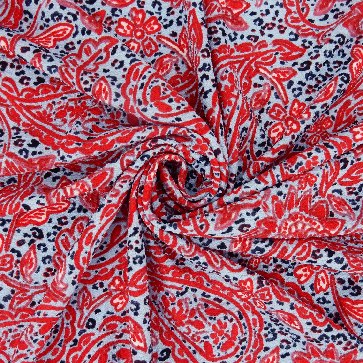 Premium textured stretch jacquard dress fabric. Luxury lightweight polyester spandex blend. Red & sky blue paisley design. shown swirled