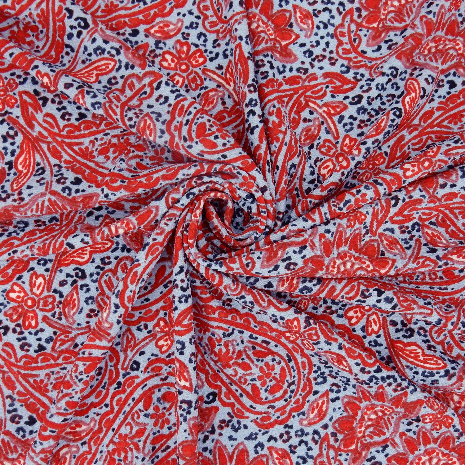 Premium textured stretch jacquard dress fabric. Luxury lightweight polyester spandex blend. Red & sky blue paisley design. close up swirl shown