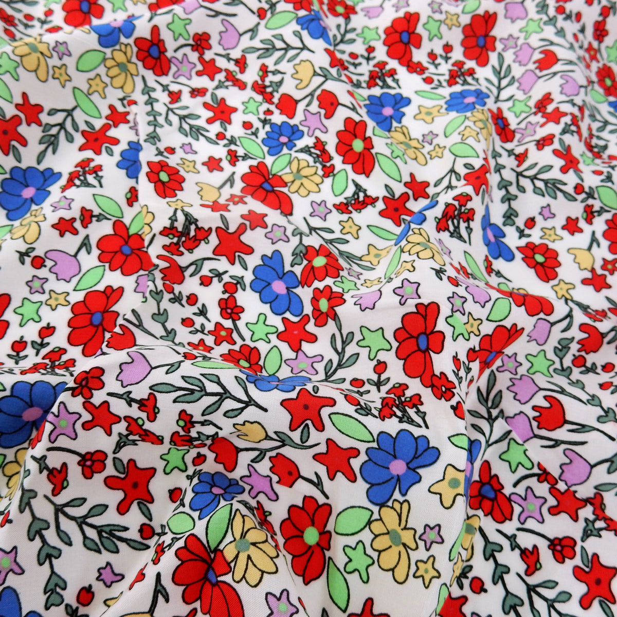 Premium 100% Rayon Challis Fabric. Playful Millefleurs Floral in Red, Periwinkle, Soft Yellow, Lilac & Mint. lightweight & ultra soft. shown lightly gathered