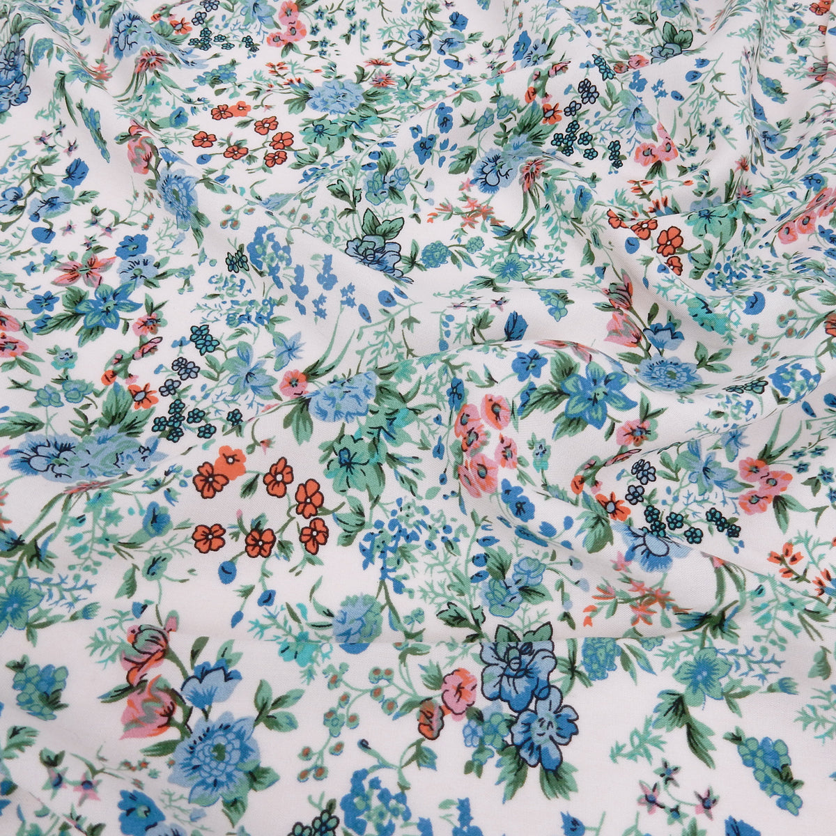 Premium 100% Rayon Challis Fabric. Playful Millefleurs Floral in Sky Blue, Terracotta, Royal Blue on Cream lightweight & ultra soft. shown lightly gathered