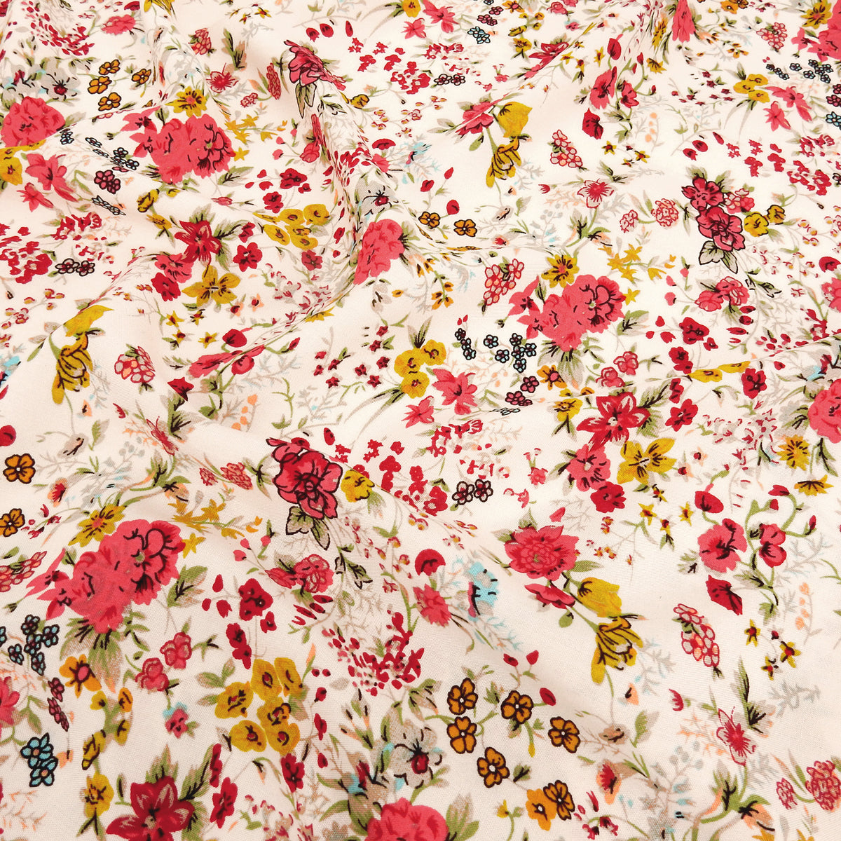 Premium 100% Rayon Challis Fabric. Playful Millefleurs Floral in Red Rose, Gold & Sky Blue on Pale Pink background. lightweight & ultra soft. shown lightly gathered