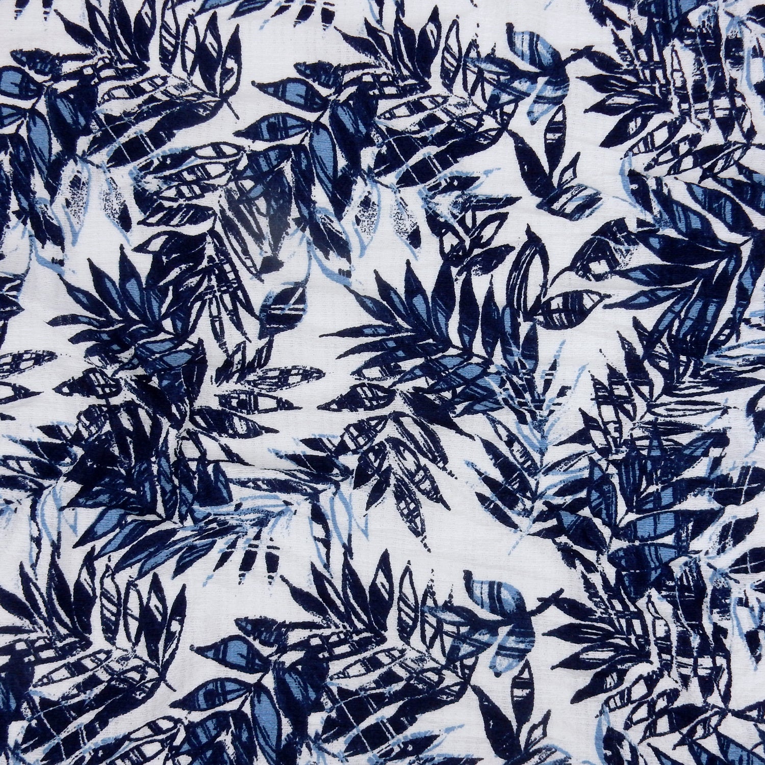 Premium  textured stretch jacquard apparel fabric. Luxury lightweight polyester spandex blend.  deep navy & breezy chambray blue tropical leaf design. shown flat