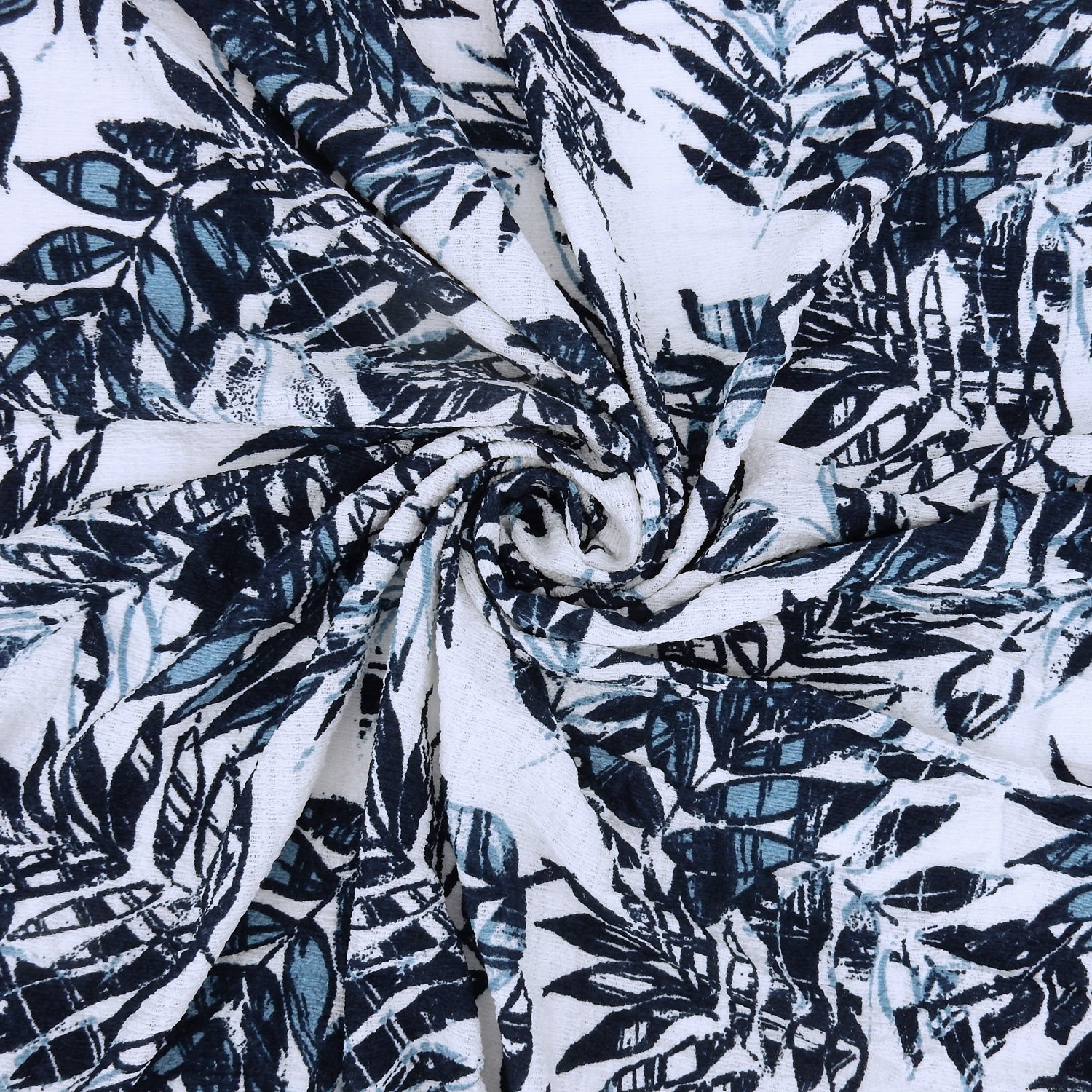 Premium  textured stretch jacquard apparel fabric. Luxury lightweight polyester spandex blend.  deep navy & breezy chambray blue tropical leaf design. shown swirled
