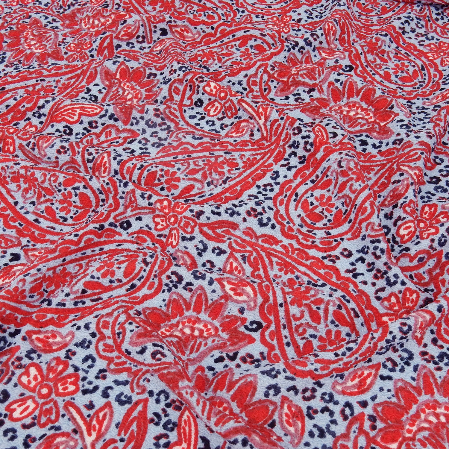 Premium  textured stretch jacquard dress fabric. Luxury lightweight polyester spandex blend. Red & sky blue paisley design. shown slightly gathered