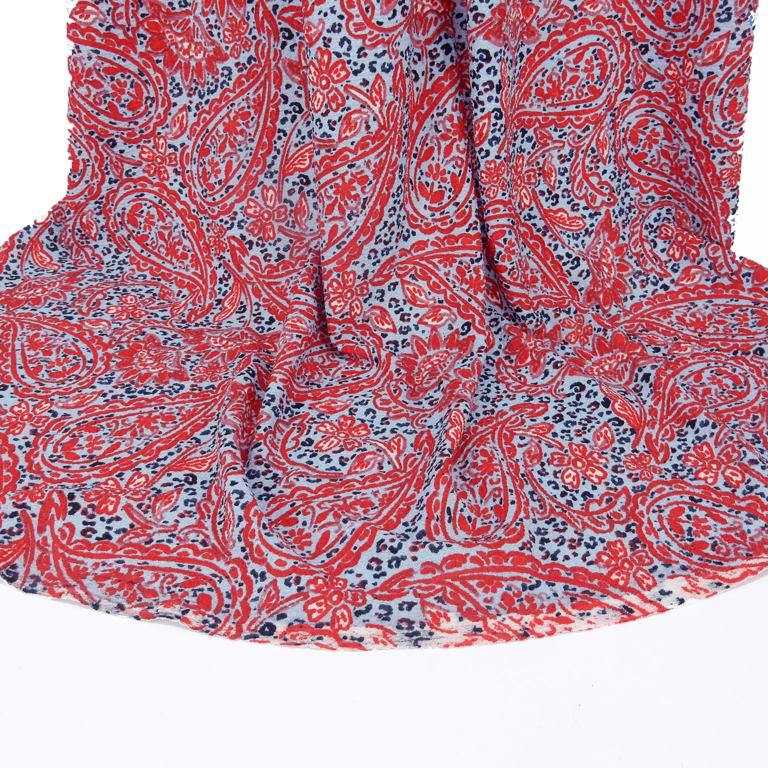Premium  textured stretch jacquard dress fabric. Luxury lightweight polyester spandex blend. Red & sky blue paisley design. shows bottom of drape