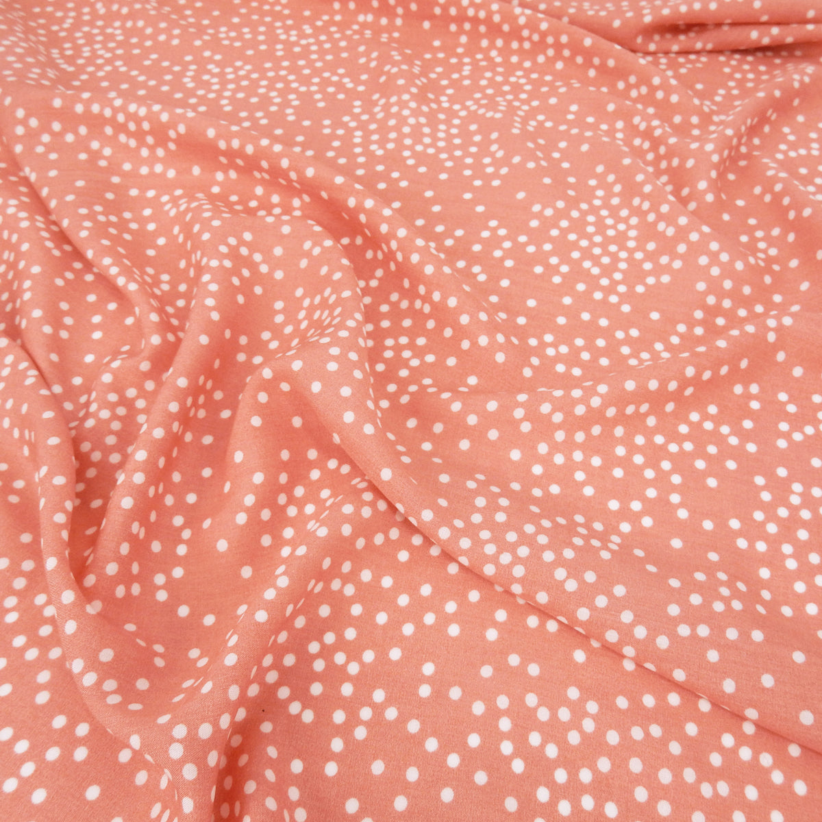 Premium 100% Rayon Challis Fabric. Artfully Spaced Polka Dot on Soft Coral. lightweight & ultra soft. shown lightly gathered