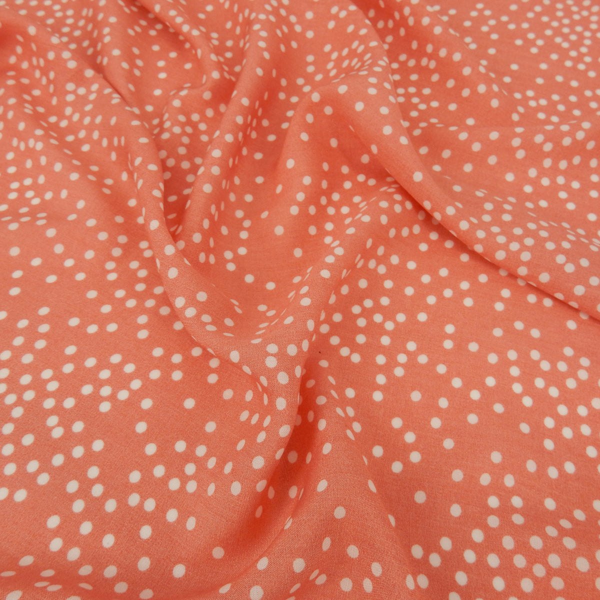 Premium 100% Rayon Challis Fabric. Artfully Spaced Polka Dot on Soft Coral. lightweight & ultra soft. shown lightly gathered