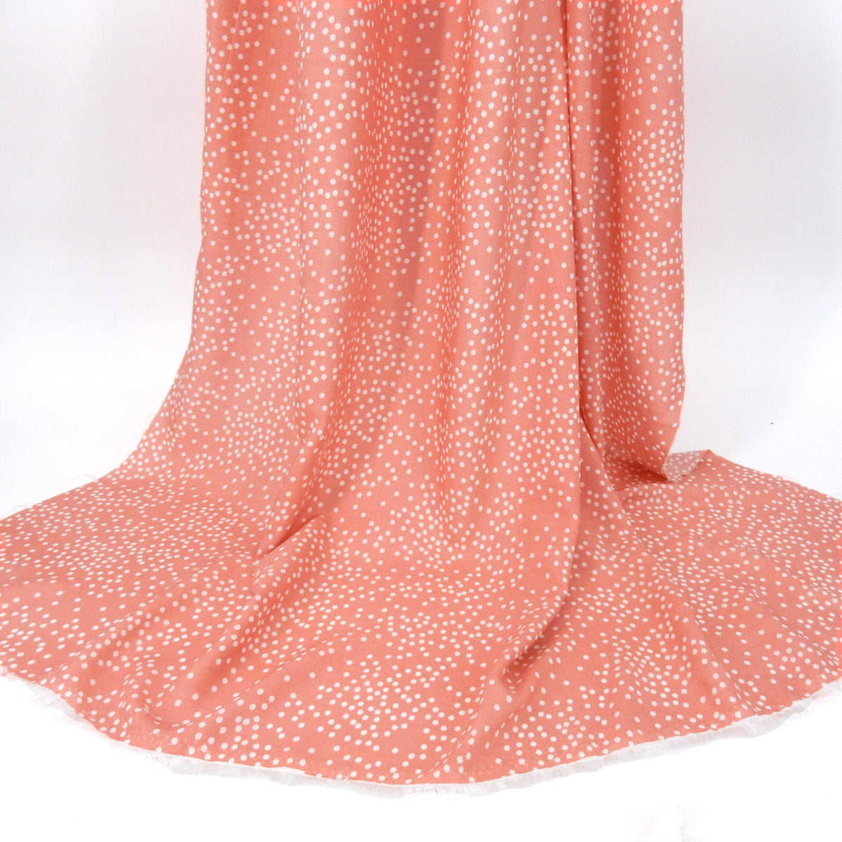 Premium 100% Rayon Challis Fabric. Artfully Spaced Polka Dot on Soft Coral. lightweight & ultra soft. shown draped