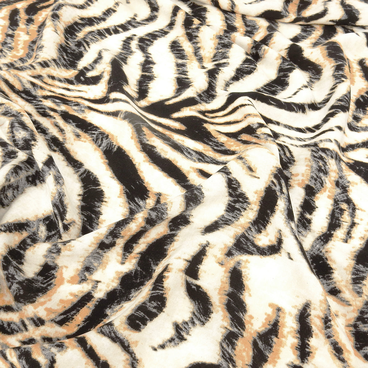 Premium 100% Rayon Challis Fabric. Artistic Tiger Stripe Print in Soft Orange, Charcoal & Creamy White. lightweight & ultra soft. shown lightly gathered