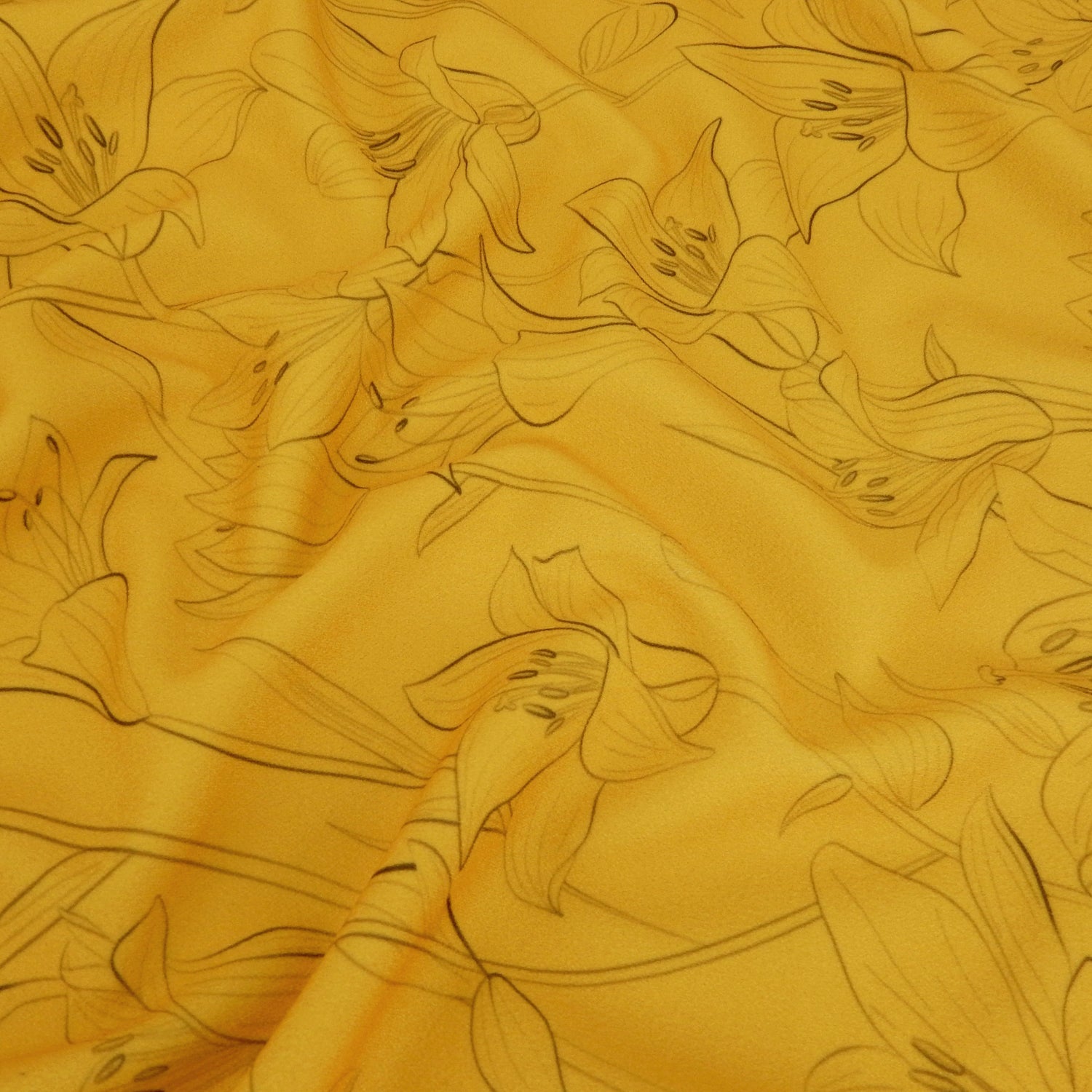 Premium Pebble Crepe Double Stretch Knit Fabric.  Lily floral design on rich gold 2-way stretch polyester crepe. shown lightly gathered