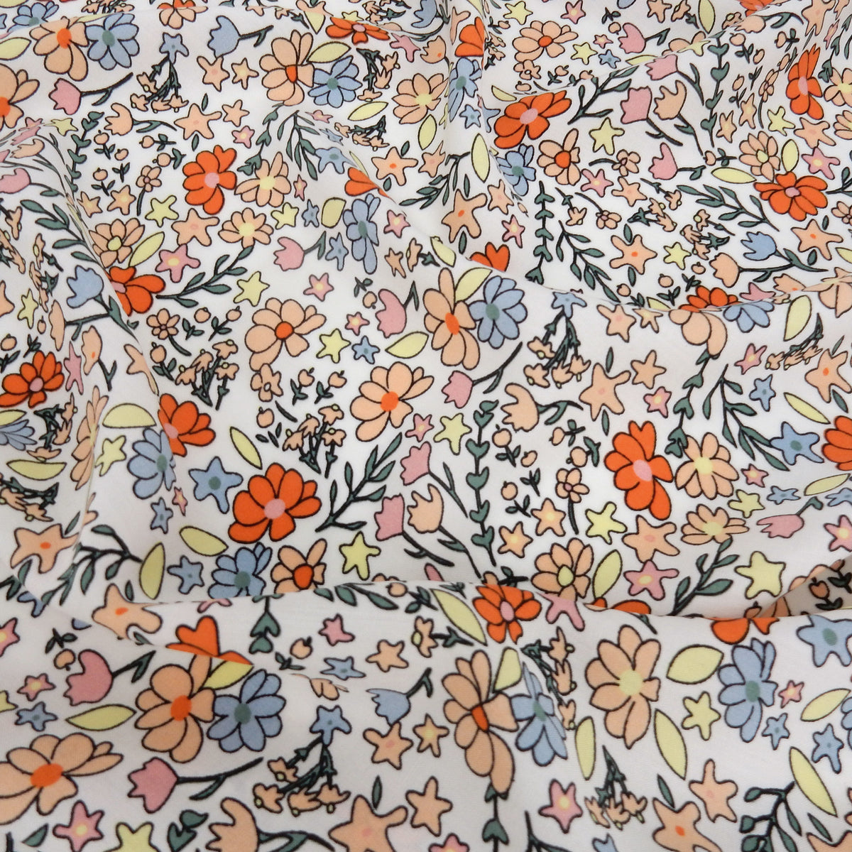 Premium 100% Rayon Challis Fabric. Playful Millefleurs Floral in Burnt Orange, Peach, Dusty Blue, Soft Yellow & Pink. lightweight & ultra soft. shown lightly gathered