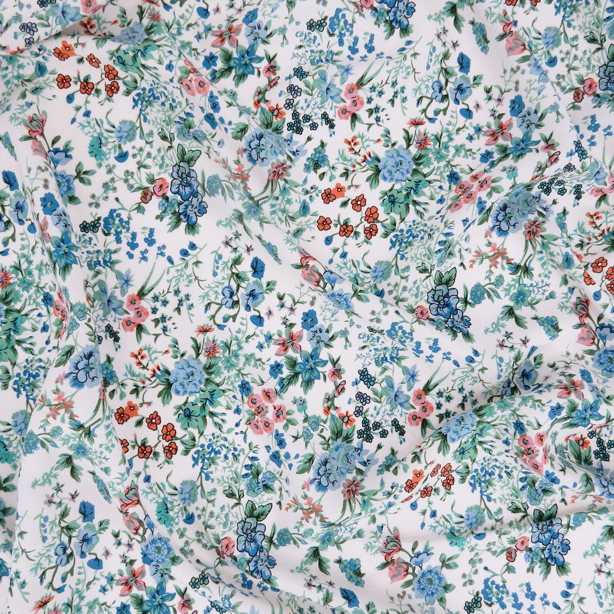 Premium 100% Rayon Challis Fabric. Playful Millefleurs Floral in Sky Blue, Terracotta, Royal Blue on Cream lightweight & ultra soft. shown lightly gathered